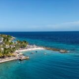 Aerial view of Jan Thiel Beach, Curaçao — crystal clear turquoise water and palm-lined shore